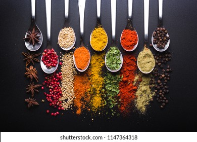Spices and condiments for cooking on a black background - Shutterstock ID 1147364318