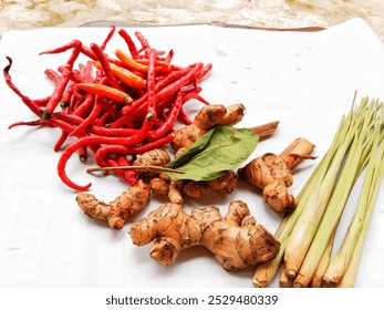 Spices consisting lemongrass, galangal, ginger, turmeric, bay leaf, and chilli place on a white background.  - Powered by Shutterstock