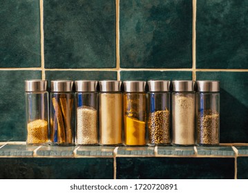 Spices in glass jars in the kitchen. A set of spices (turmeric, coriander, pepper, cinnamon, mustard) for home cooking. - Powered by Shutterstock