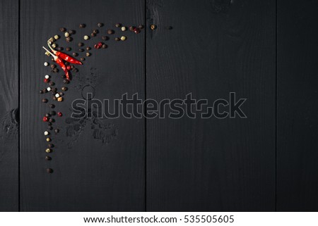 Spices, papper on black wooden background. Top view. Free space.