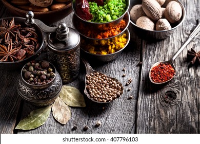 Spices, Pepper Grinder, Spoon With Seeds Close Up At Grey Wooden Background 