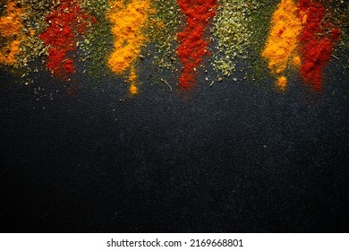 Spices powder on black slate background top view.