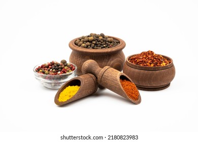 Spices in wooden bowls and spoons, pepper mixture in glass bowl isolated on white background. - Shutterstock ID 2180823983