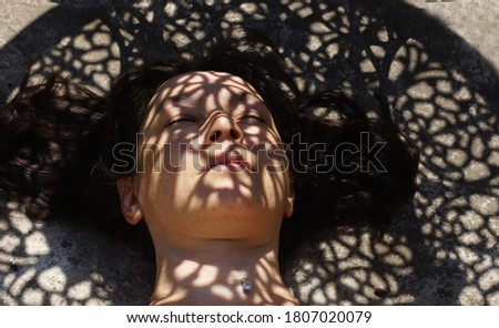 SPictorial portrait of a girl's face with a curly shadow on her face                      