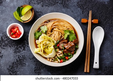 Spicy Asian Noodles In Broth With Beef On Dark Background