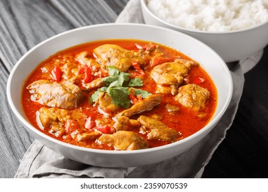 Spicy Burmese chicken curry in a sauce consisting of onion, ginger, lemongrass, pepper, garlic and tomato close-up in a bowl on the table. Horizontal - Shutterstock ID 2359070539