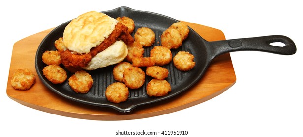 Spicy Chicken Biscuit And Hashbrowns On Skillet Isolated Over White