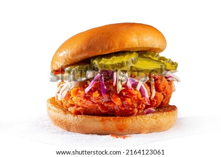 Spicy chicken sandwich with coleslaw and pickles on a brioche bun
