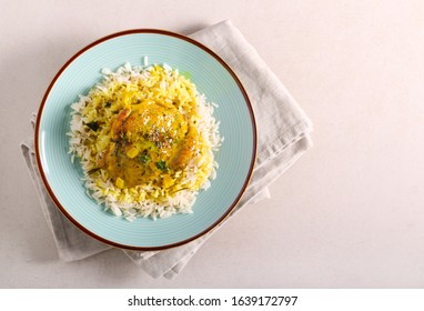 Spicy chicken thigh with gravy and rice, on plate