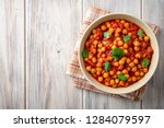 Spicy Chickpea curry Chana Masala in bowl on wooden table. Traditional Indian dish. Top view. Copy space.