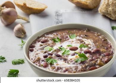 Spicy Creamy Black Bean Soup In A White Bowl On A Concrete Background.