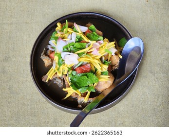 Spicy crispy gourami fish and mango salad with Sweet Fish Sauce. Spoon in a food plate