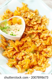 Spicy farfalle pasta chips with homemade herb dip