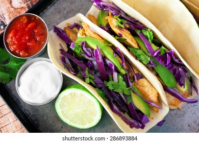 Spicy Fish Tacos With Red Cabbage Slaw, Avocado And Lime Juice, Overhead View On Vintage Tray