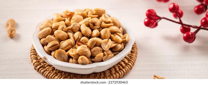 Spicy flavored peanut kernel in a bowl on white table background.