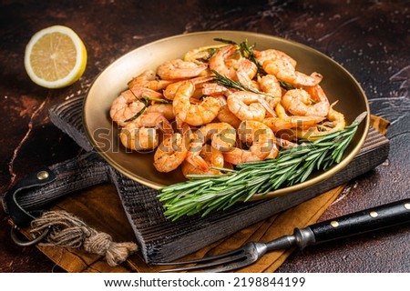 Spicy garlic chilli Prawns Shrimps with lemon and rosemary on a plate. Dark background. Top view. Foto d'archivio © 