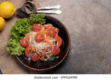 Spicy Glass Noodle Salad With Salted Egg Yolk In A Black Plate