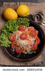 Spicy Glass Noodle Salad With Salted Egg Yolk In A Black Plate