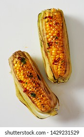 Spicy Grilled Corn On The Cob Seasoned With Chili From A Summer Barbecue Viewed From Above On White In A Healthy Diet And Seasonal Cuisine Concept