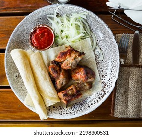 Spicy Grilled Pork Meat Served With Hot Tomato Sauce, Onion And Flatbread