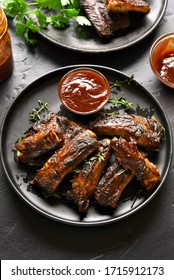 Spicy Hot Grilled Spare Ribs On Plate Over Black Stone Background. Tasty Bbq Meat. 