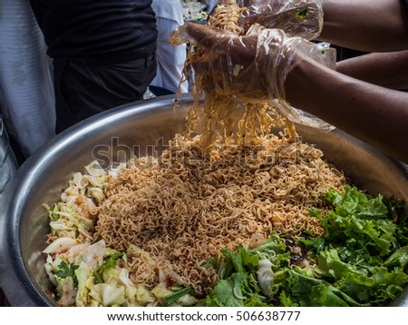 Spicy instant noodle with cabbage, coriander, lettuce, mushroom, prepare for donation during "Kratin Festival" in Thailand.