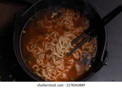 Spicy Korean Instant Noodles With Wakame Seaweed In A Black Iron Pot, Korean Food Traditional Style