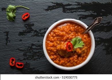 Spicy Lentil And Meatball Soup With Parsley. White Bowl On Black Stone Background, Top View.