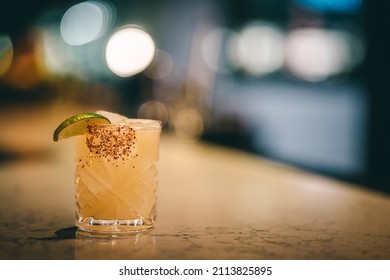 Spicy Margarita With A Tajin Rim Sitting On The Bar Top.