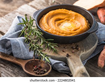 Spicy mashed sweet potato or sweet potato puree with rosemary in a saucepan on a table.  top view from above