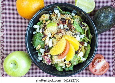 Spicy nutty fruity quinoa salad in black ceramic bowl., Homemade quinoa with spinach and fruit salad - Powered by Shutterstock