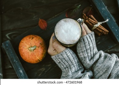 Spicy pumpkin latte on a wooden board with a sweater