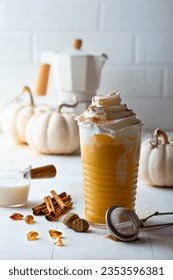 Spicy pumpkin latte with whipped cream. Autumn or winter hot coffee drink with cinnamon, nutmeg and cookies