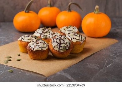 Spicy Pumpkin Muffins Decorated Ghosts, Spiderweb For Halloween Celebration. Autumn Composition With Pumpkins, Cupcakes On Dark Stone Table. Fall Time. Selective Focus. Autumn Dessert.