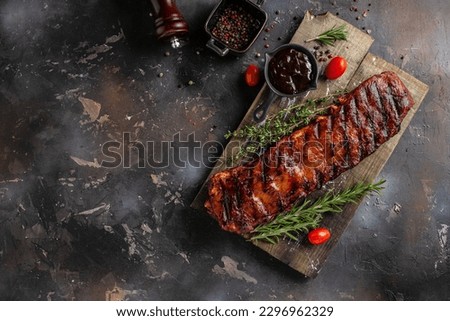 Spicy rack of spare ribs with marinade on a wooden board, banner, menu, recipe place for text, top view.