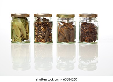 Spicy range. A range of four transparent glass jars of different spices and herbs. - Powered by Shutterstock