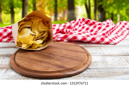 Spicy Red Chilli Potato Chips And Empty Board On A Wooden Table