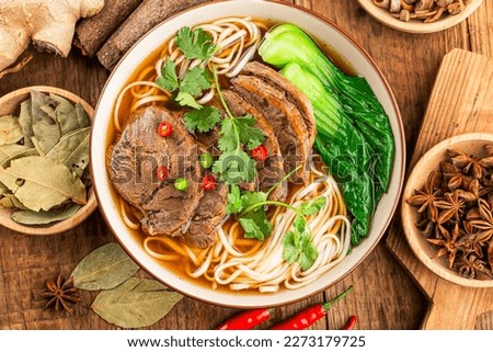 Spicy red soup beef noodle in a bowl on wooden table