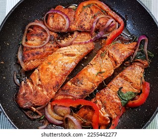 Spicy Salmon fish with fresh tomato, sweet red bell pepper and lemon cooked in frying pan - Shutterstock ID 2255442277