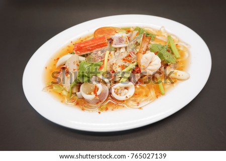 Spicy seafood salad is a Thai food for health consists of vermicelli, squid, shrimp, onion, chili and herb mixed (Ingredient can put anything you want squid or food) in plate 
