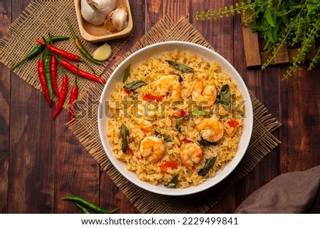Spicy Shrimp Fried Rice with thai holy basil leaves in white plate.Top view