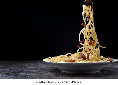 Spicy Spaghetti With Chilli And Bacon, Tastly Food. Some Of Spagetti Roll On The Stainless Fork On White Plate, Copy Space For Text.