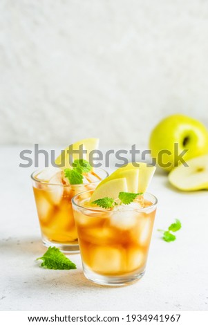 Spicy summer apple cocktail, apple iced tea in glasses. Space for text.