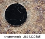 Spider Web Inside a Circular Rusted Metal Hole Close Up Texture Background. 
Close-up photograph of a circular hole in weathered rusted metal with delicate spider webs inside, creating an abstract industrial texture background.