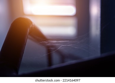 Spider Webs And Dust In Abandoned Old House With Light Shining From The Window.