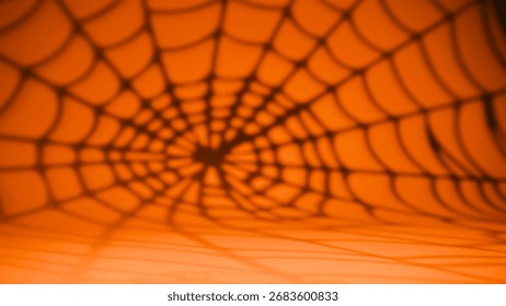 Spiderweb shadow pattern on vivid orange background for Halloween.