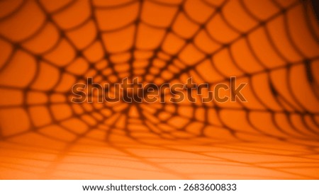 Spiderweb shadow pattern on vivid orange background for Halloween.