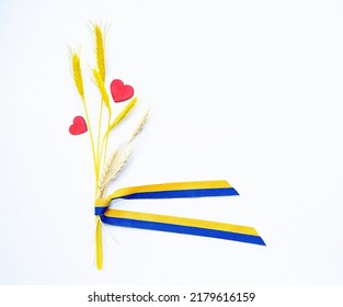 Spikilets (ears Of Wheat) And Two Red Hearts With Yellow-blue Ribbon (yellow And Blue Are Colors Of National Flag Of Ukraine) On White Background.   Europe. Ukraine. Copy Space. Empty Space.