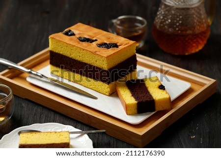 Spiku or Lapis Surabaya, Indonesian  Three Layer Cake with with Strawberry Jam Between the Layer. Topped with Prunes. Served with Tea