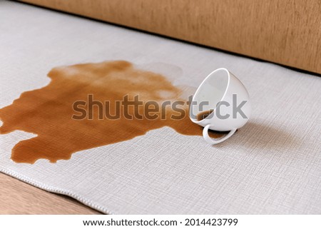 Spilled coffee on a white carpet. The concept of cleaning stains. High quality photo